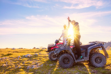 Rear view of young pair near atv. Man is showing something in distance to her girlfriend. © FS-Stock