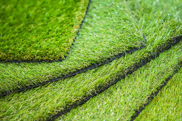 Green artificial turf. Probes examples of artificial turf, floor coverings for playgrounds.