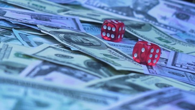 Red dice falling on money