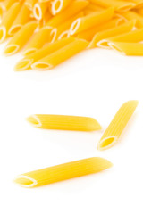 Closeup of raw, uncooked, dry penne pasta noodles with selective focus