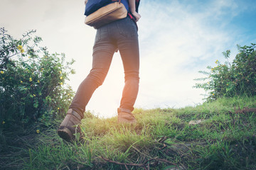 Close-up of female hiker feet walking on forest trail. Active woman backpacker traveling on the nature.