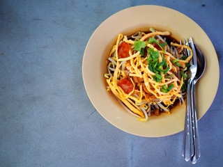 Top view Thai local traditional street stall food: Steamed rice tube shape noodle with tofu, fried Chinese sausage, egg, bean sprout, black sour soy sauce, served in pink plastic plate