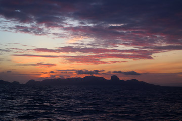 Naklejka na ściany i meble The clouds and purple red sky before sunrise in the ocean