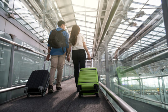 Asian Couple Traveler With Suitcases At The Airport. Lover Travel And Transportation With Technology Concept.