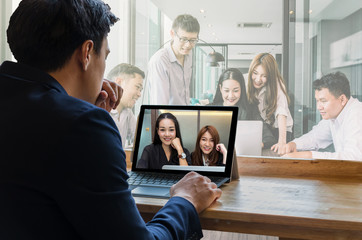 Obraz premium Businessman sitting and using computer laptop showing Group of asian Business team having video conference via monitor display in the modern conference room, Business people meeting concept