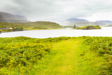Fototapeta na wymiar ruined castle on the island in the center of northern Scotland lake