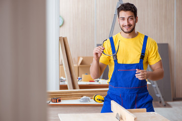 Young repairman carpenter working cutting wood on circular saw