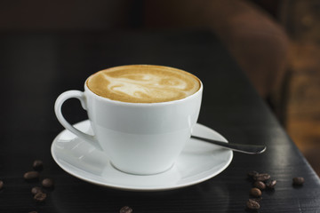 The cup of coffee on the black table in cafe