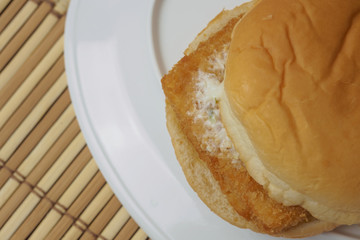 Low cost burger fish steak on bamboo mat
