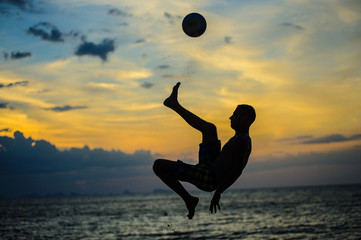 Kicking a ball. Silhouette of a man on a beach