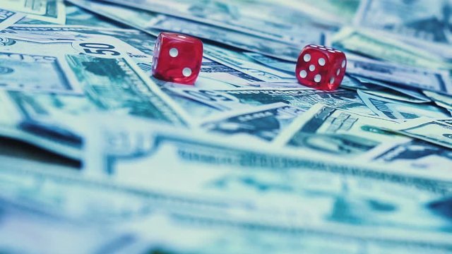 Red dice falling on money slow motion