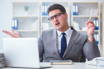 Businessman smoking in office at work