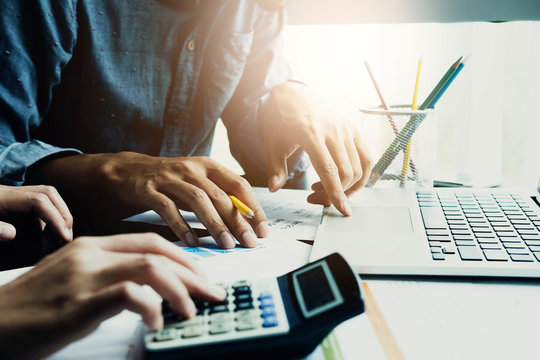 Business People Using Calculator And Laptop Computer For Discussion About Profit, Tax, Financial