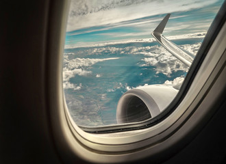 Beautiful view from  porthole of airplane on sky with clouds und
