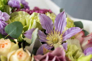 Close-up floral composition with roses and mix flowers on a light background.