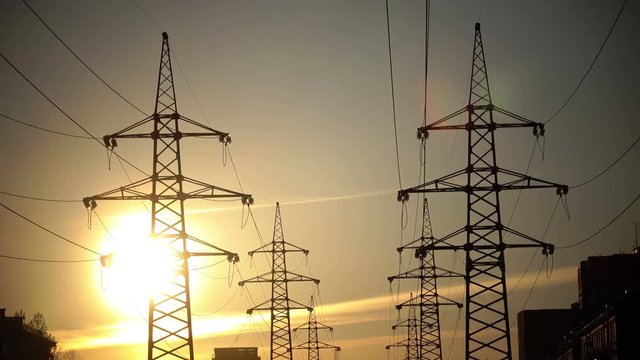 Electric support of high voltage power cables. Energy industry. Production, distribution and transmission of electricity. power lines. Power substation in the big city during sunset