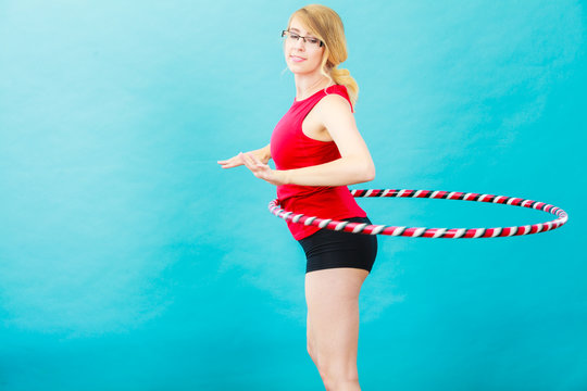 Fit woman with hula hoop doing exercise