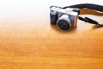 digital photography concept with mirrorless camera on wooden table with room for text