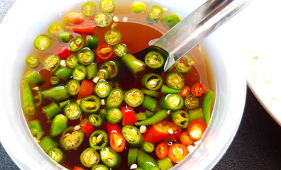 fish oil sauce with red and green chili in ceramic bowl