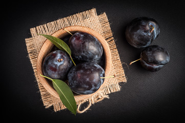 Garden plums in bowl on stone table. View with copy space