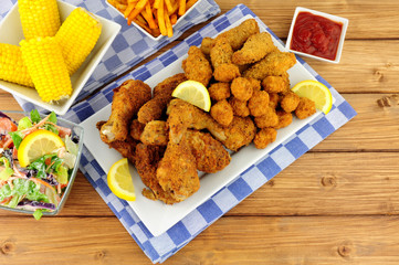 Collection of Southern fried chicken products with sweetcorn and salad