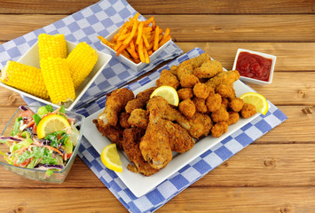 Collection of Southern fried chicken products with sweetcorn and salad