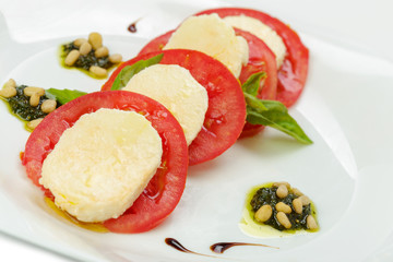 mozzarella with tomato and basil isolated on white