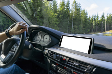 Male hands holding car steering wheel. Hands on steering wheel of a car driving near the lake. Man driving a car inside cabin. Multimedia system isolated white blank screen. Copy space