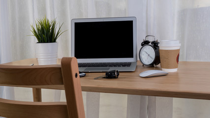 Laptop with smart phone notebook and coffee cup on workplace table.