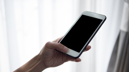 Woman hand holding phone. People using smart phone working from home.