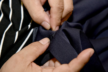 Closeup hands of Tailor man working in his cloth fabric in shop, Tailoring, close up.