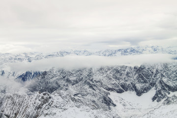 Obraz premium View of a mountain range with snow and clouds