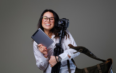 Naklejka premium Female photographer holds tripod and tablet PC.