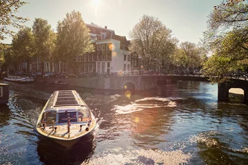 Fotobehang Amsterdam canal with tourist boat © Dmitry Rukhlenko