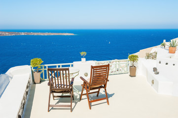 Two chairs on the terrace with sea view. Santorini island, Greece.