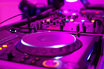 Close-up photo of pro DJ Controller in purple light