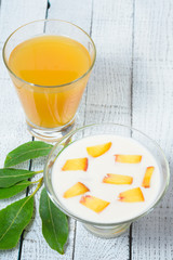 Yogurt with diced peaches and juice on the table.