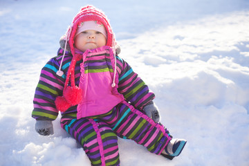 Fototapeta na wymiar little baby sitting on a snow, winter day