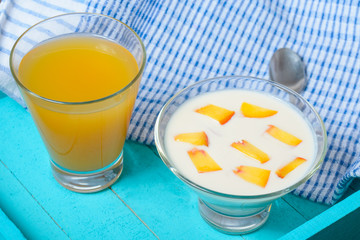 Yogurt with diced peaches and juice on the table.