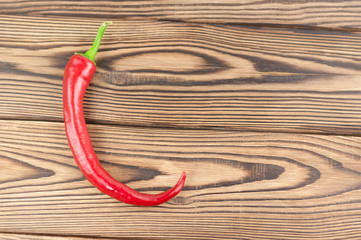 Red whole fresh ripe chili pepper on old brown wooden rustic planks