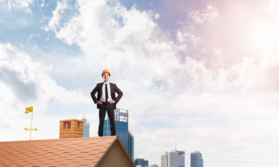 Engineer man standing on roof and looking away. Mixed media