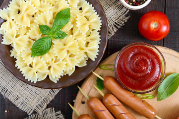 Farfalle pasta, sausages on skewers, spicy tomato sauce. Italian Cuisine.