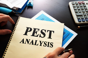 Book PEST analysis business on a desk.