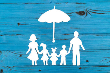 Closeup of happy paper family on blue background
