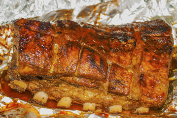 pork ribs out of oven marinated and ready for grilling on hot burning charcoal barbecue close-up