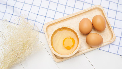 Chicken egg on a wooden plate.