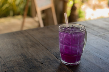 Butterfly pea with lime juice on wood table.