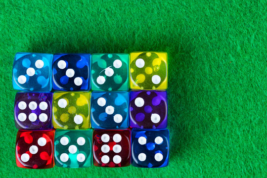 Colorful dice on a green casino background.