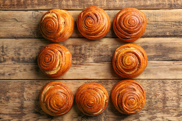 Sweet cinnamon rolls on wooden table