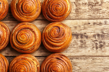 Sweet cinnamon rolls on wooden table